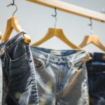 Jeans - selective focus photography of hanged denim jeans