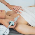 Skincare Technology - A Woman Lying Down with Towel on Her Body